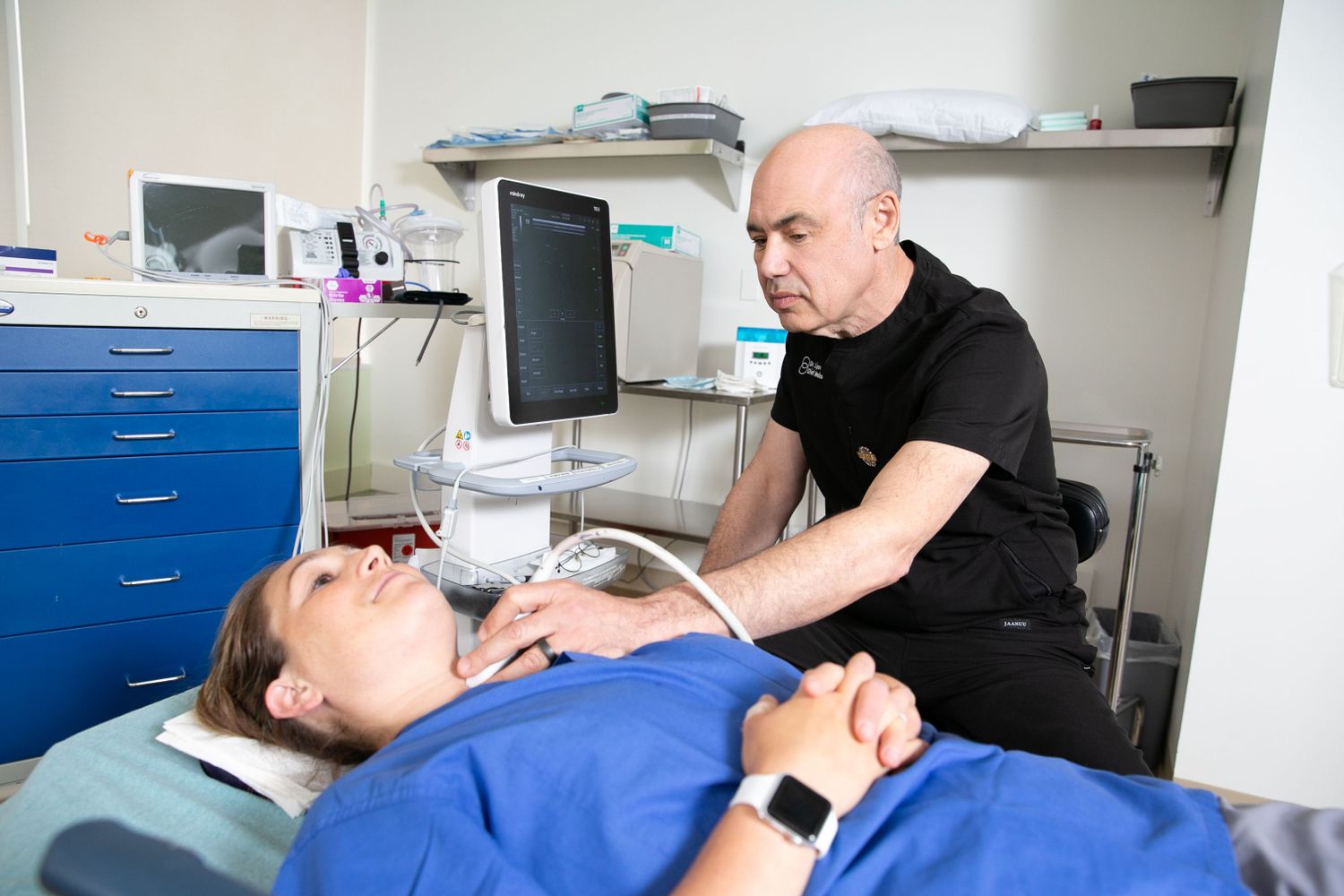 Dr. Lipov examines a patient 's neck with an ultrasound